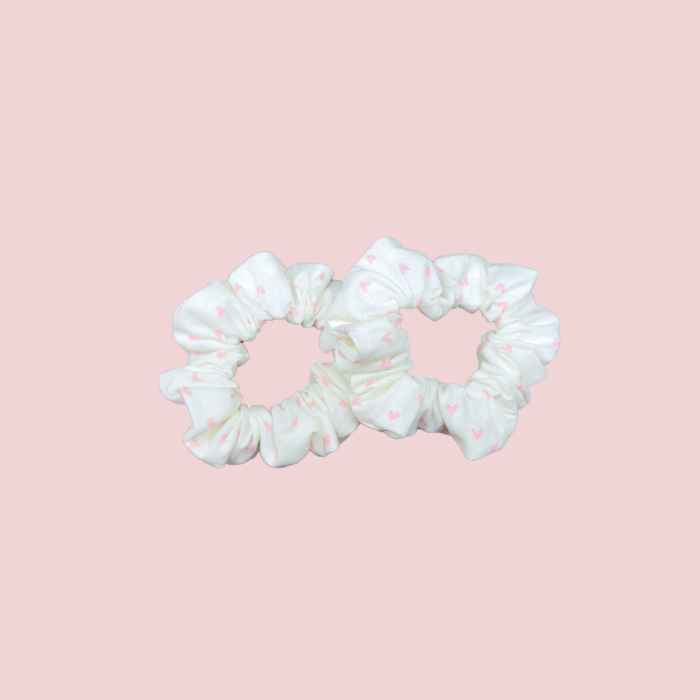 Kids mini scrunchies in white with pink hearts, perfect for adding a playful touch to hairstyles.