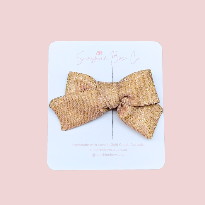 Sparkling pink hair bow, adding shimmer and charm to any hairstyle.