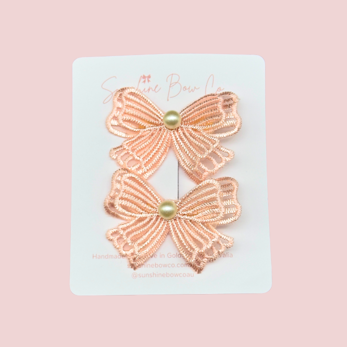 Set of two little girls' hair clips featuring pink lace bows, perfect for adding whimsy to hairstyles.